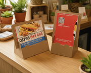 Cardboard stand with printed food menu and contact information on a white background